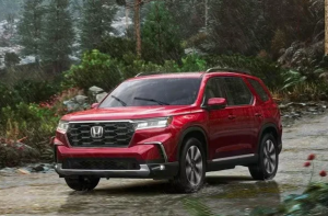 A red 2024 Honda Pilot driving off-road near Indianapolis, Indiana.