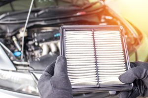 A mechanic holding a car's air filter in a service center near Indianapolis, IN