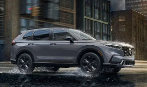 A grey 2024 Honda CR-V driving down a rainy street near Indianapolis, Indiana
