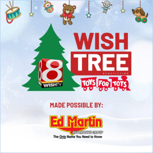 A colorful holiday graphic featuring a green Christmas tree, the text "WISH TREE" and "TOYS FOR TOTS," along with the Ed Martin Automotive Group logo.