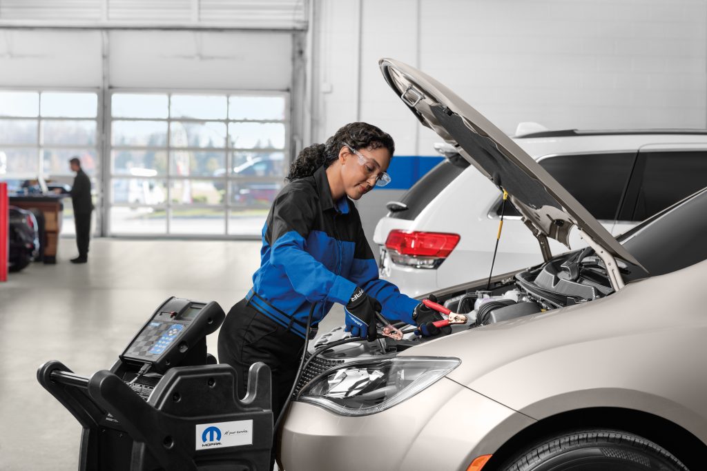 Mechanic checking car battery in service center