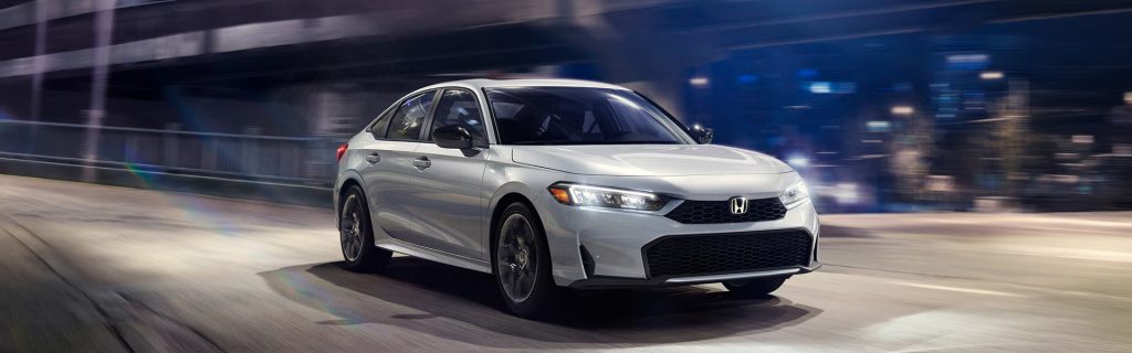 White Honda Civic Sedan Hybrid driving on city road