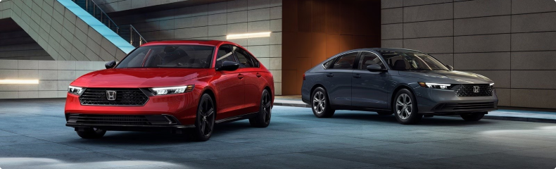 Red and grey 2026 Honda Accords parked side by side in a modern concrete plaza
