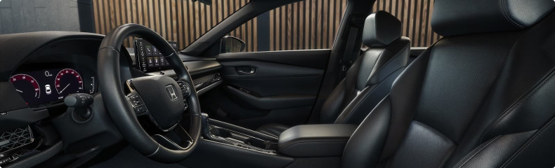 Front cabin of the Honda Accord with black leather-trimmed seats, seen through the driver’s door