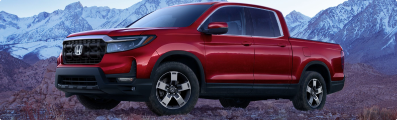 Red Honda Ridgeline parked on rocky ground below snow-capped mountains